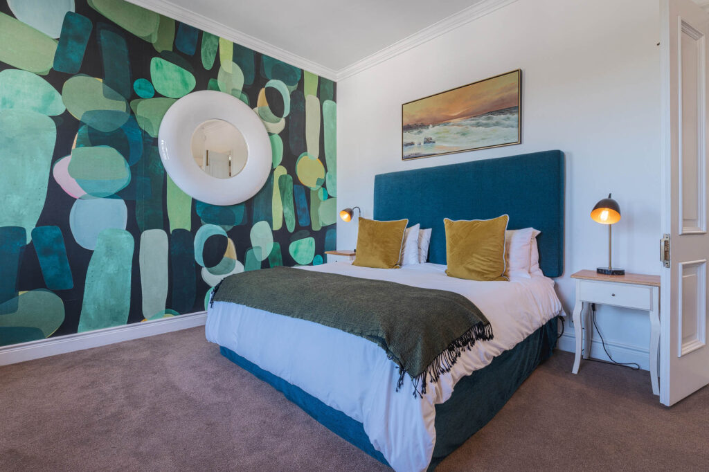 A spacious and elegantly designed bedroom, soft neutral tones, large windows offering natural light