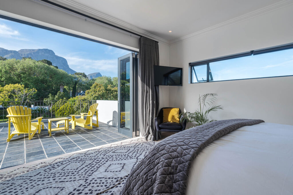 A spacious and elegantly designed bedroom, soft neutral tones, large windows offering natural light